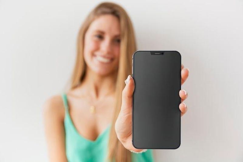 Front view unfocused woman showing her smartphone with empty screen