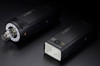 Два акумуляторні спалахи Godox AD200Pro II лежать на темному столі: зліва — з головкою H200J II та відкритою лампою для великих модифікаторів, справа — з класичною прямокутною лінзою Френеля H200 II